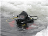 Fire Department diver surfaces from under ice.
