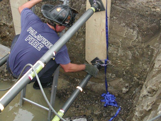 Firefighter sets pneumatic shoring during a trench rescue drill.