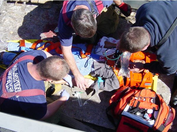 Firefighters practice medical techniques on a training mannequin during a medical / rescue training 