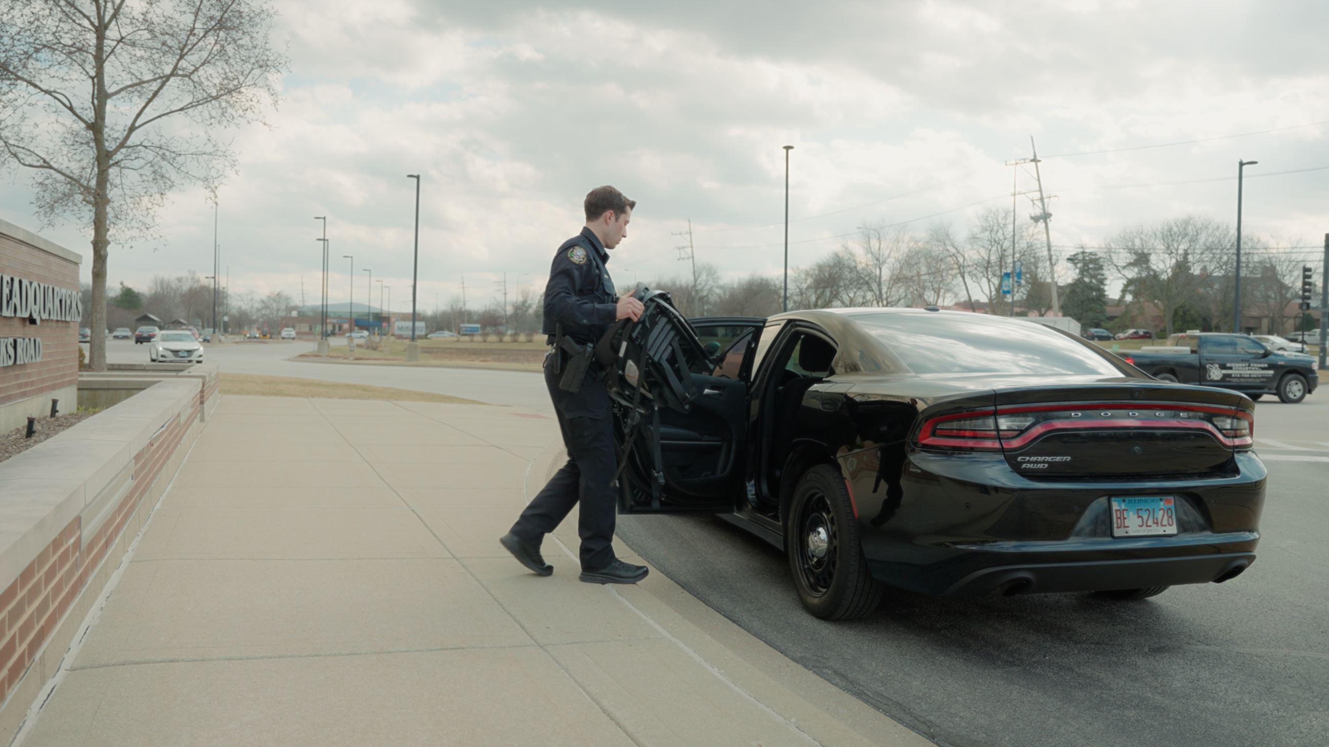 Picture of male police officer carrying child safety seat